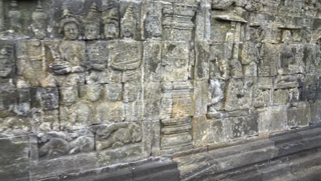 indonesia,jawa island,yogyakarta,unesco world heritage borobudur temple's inside,wall reliefs, camera slides slowly from left to right and shows the relief in details, ancient stories on the wall.