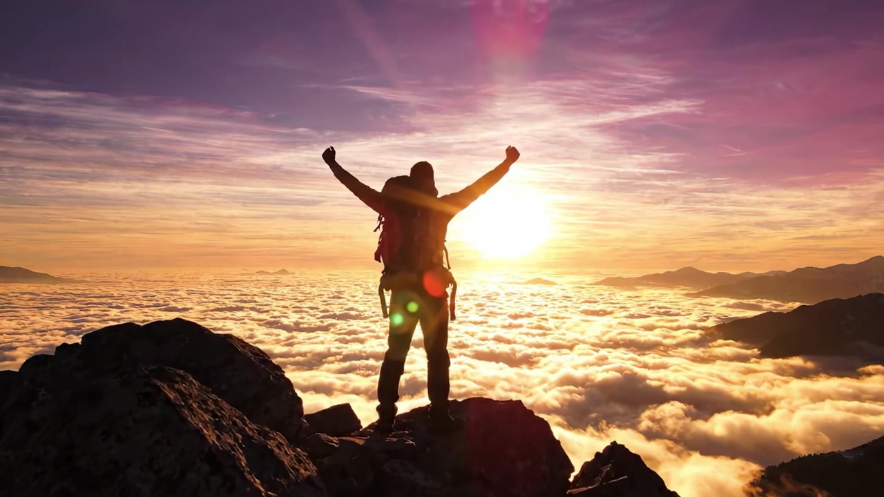 Un alpinista si erge trionfante su una cima di montagna, celebrando l'alba mozzafiato sopra le nuvole, riflettendo un momento di realizzazione e connessione con la natura