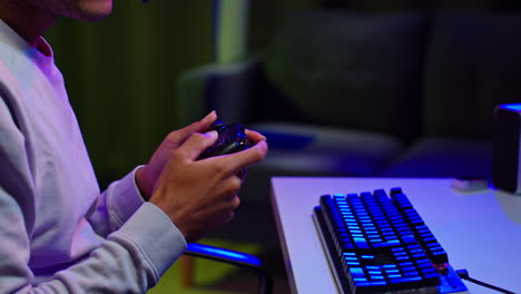 man playing video game with controller and keyboard