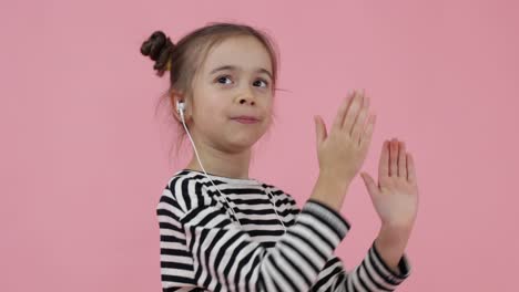 young teen child listening music via earphones and dancing disco.