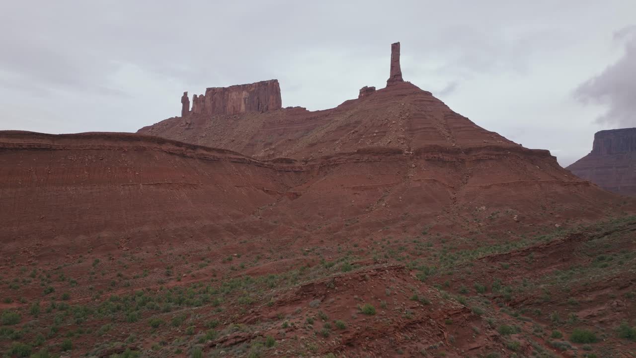 Remote red rock desert with Castleton Tower in Moab, Utah, under cloudy sky