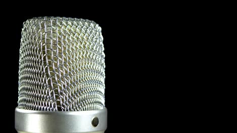 studio condenser microphone rotates on a black background