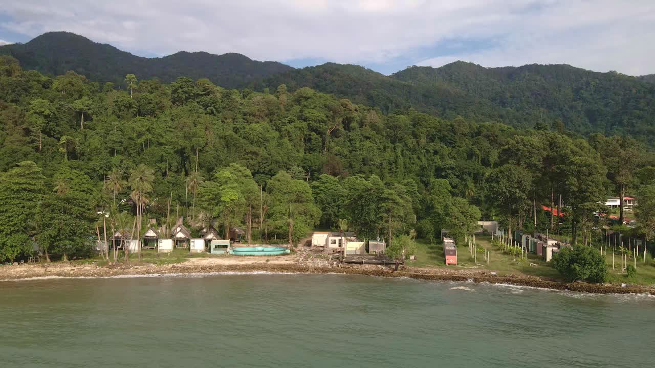 la vista aérea de los pájaros dejó un camión en movimiento con la rotación de un complejo turístico de bungalows de playa abandonado y abandonado en koh chang tailandia debido al efecto de covid en los viajes y el turismo globales