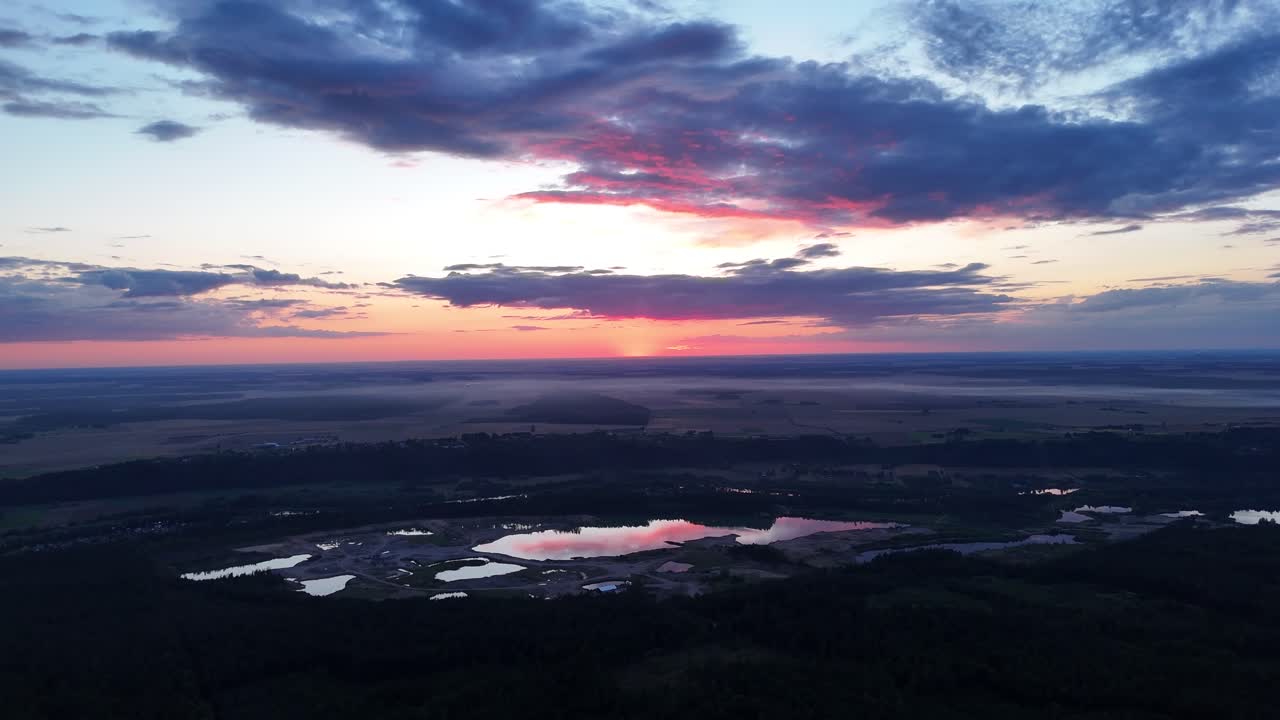 Captivating sunrise illuminates the tranquil lakes in a sprawling landscape with shades of pink and purple