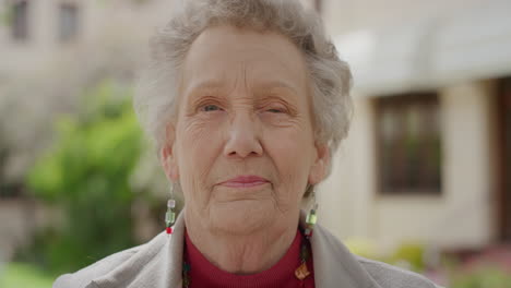 portrait of elderly woman smiling peaceful looking at camera old caucasian woman with wrinkles enjoying beautiful sunny garden outdoors retirement lifestyle