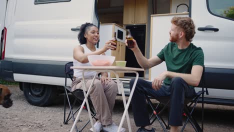 friends enjoying a picnic by their camper van with their dog