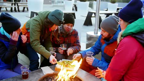 Friends-having-snacks-near-campfire