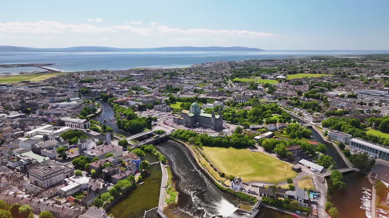 Wide aerial cityscape of Galway city with the river and Cathedral in the middle. Sunny day