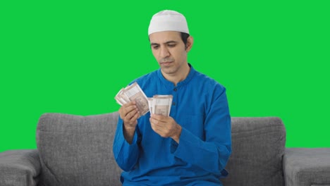 Sad-Muslim-man-counting-money-Green-screen