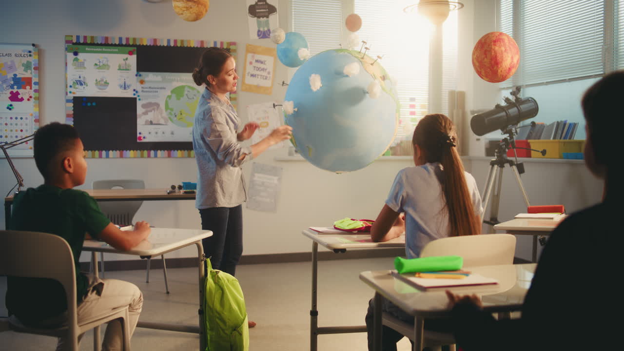 Primary School Boy Presenting Green Energy Sources in Front of Class Using Earth Model