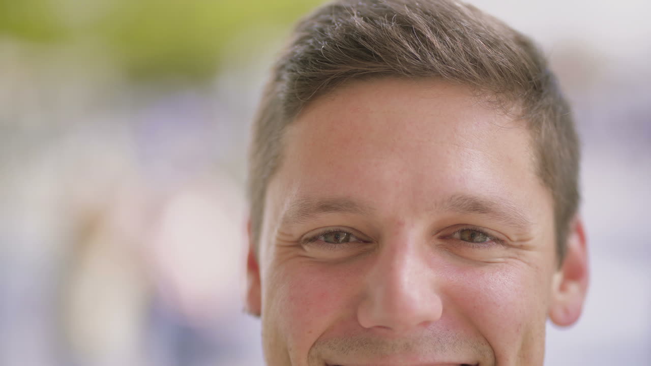 예쁜 젊은 남자가 카메라를 향해 미소 짓고 있다