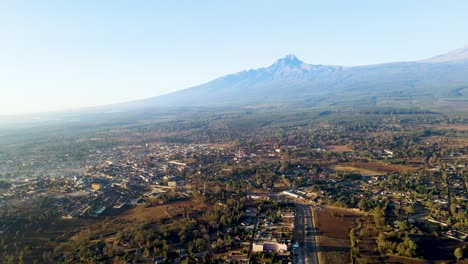 sunrise- kenya landscape with a village, kilimanjaro and amboseli national park - tracking, drone aerial view