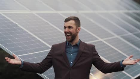 happy young man in business clothes on the background of solar panels