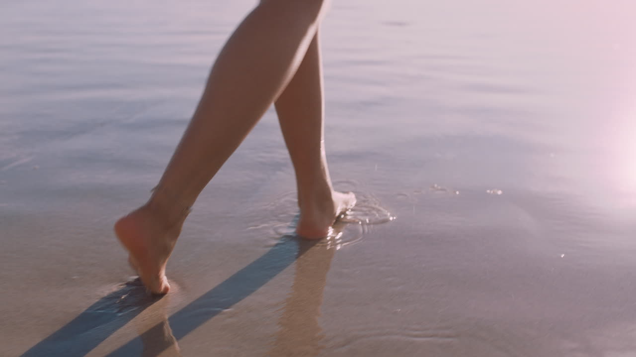 piedi di donna che camminano scalzi sulla spiaggia al tramonto lasciando impronte nella sabbia turista donna in vacanza estiva