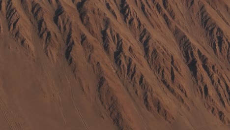 Toma-Aérea-Del-Terreno-Irregular-En-La-Ladera-De-Una-Gran-Montaña-En-Iquique,-Chile