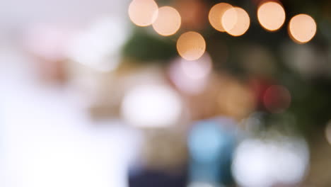 Gifts-arranged-under-a-decorated-Christmas-tree-with-red-baubles,-close-up,-rack-focus,-bokeh,-handheld