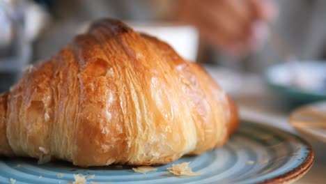 cerca de un croissant recién horneado en un plato azul