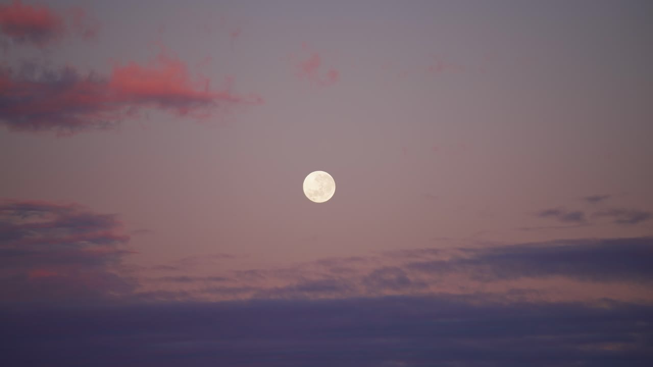 다채로운 구름으로 둘러싸인 아침이나 저녁 하늘의 보름달