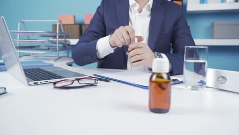 Close-up-sick-businessman-drinking-his-medicine-in-the-office.