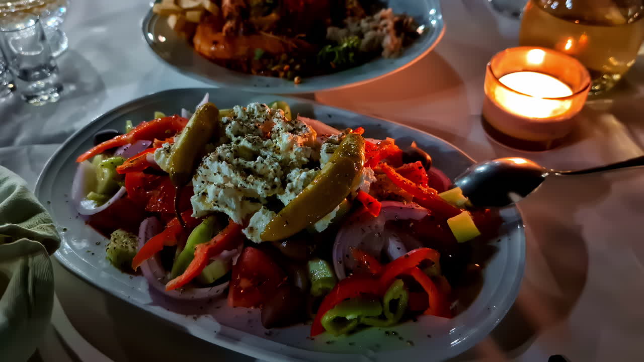 Salad plate with raw pepper and cheese on a candlelight table in restaurant