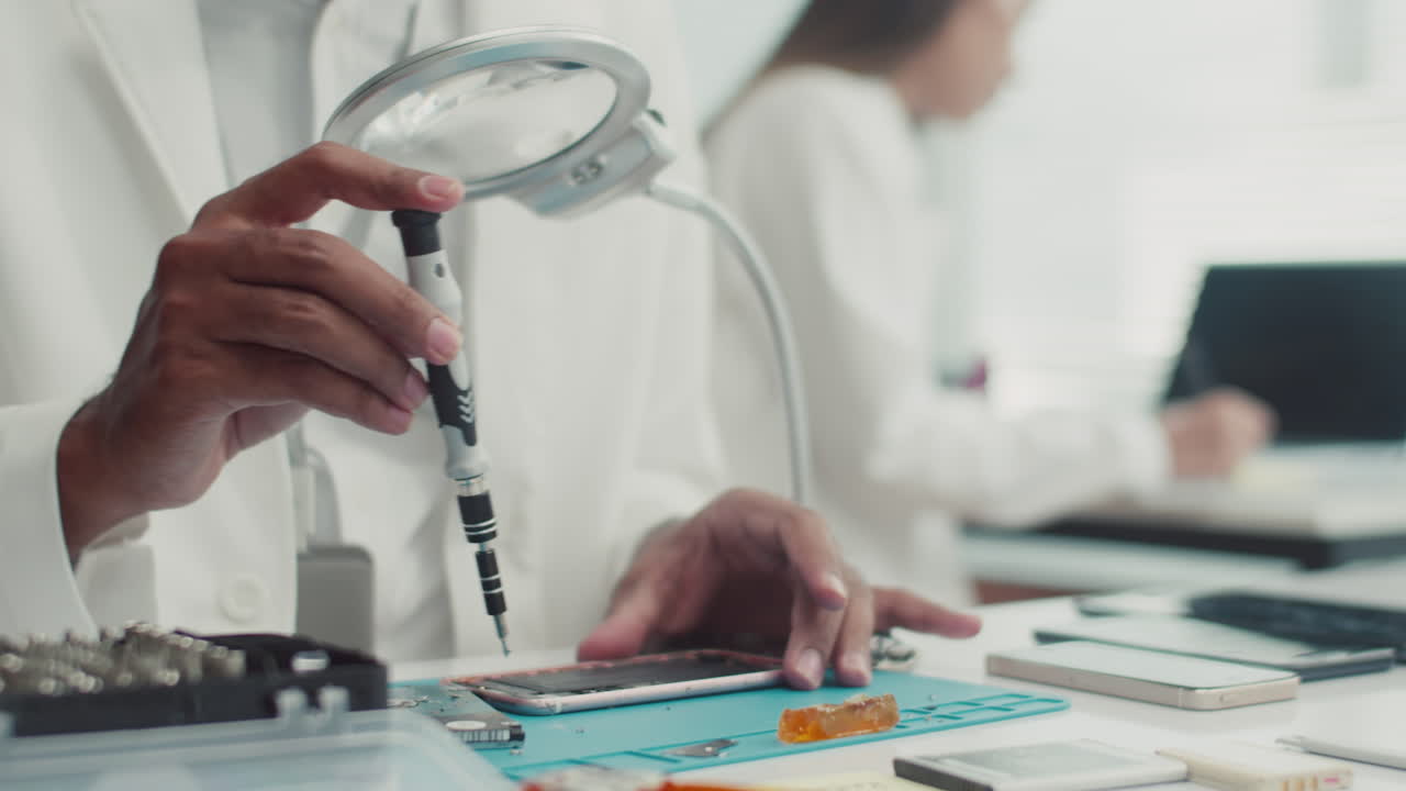 Specialist Removing Broken Smartphones Detail with Screwdriver