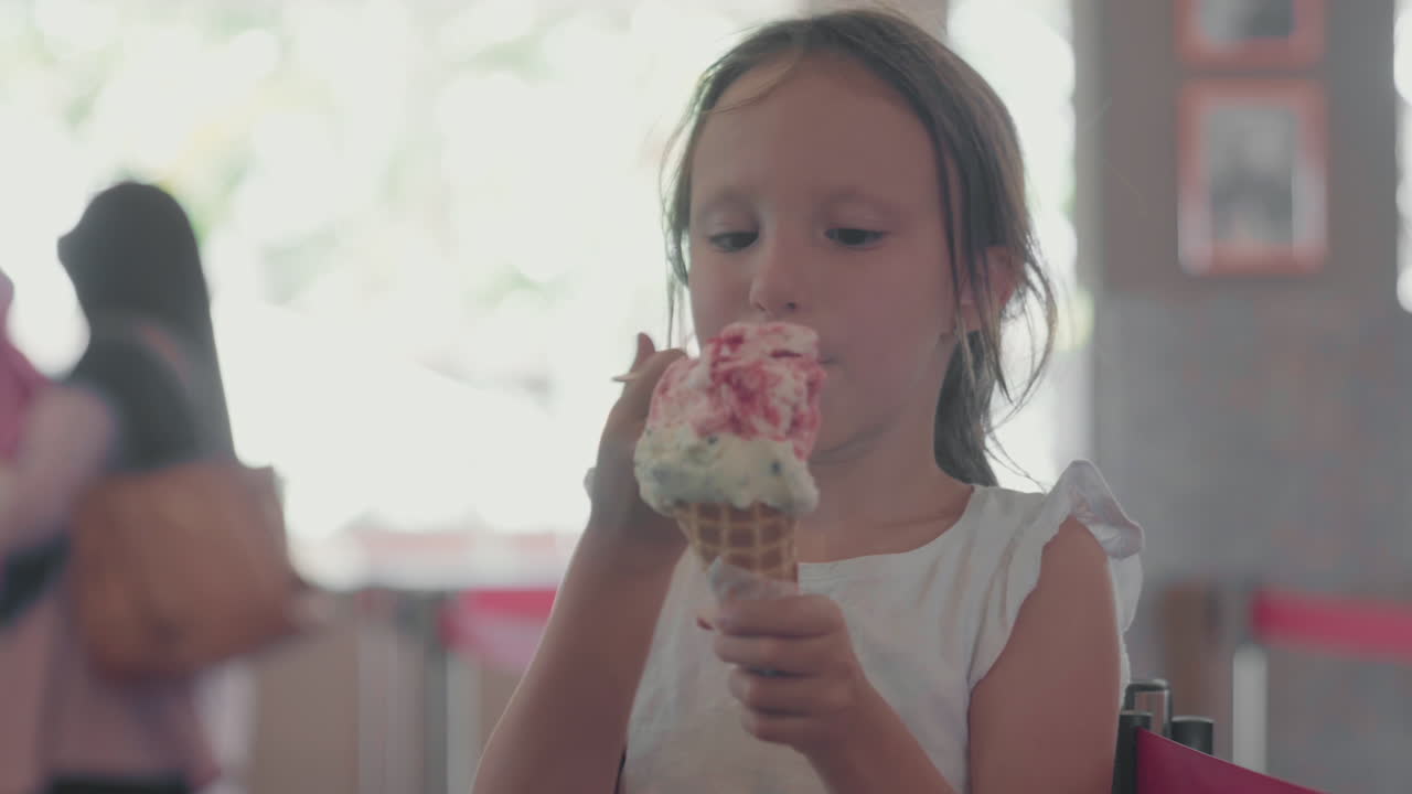 una adolescente comiendo helado en un café