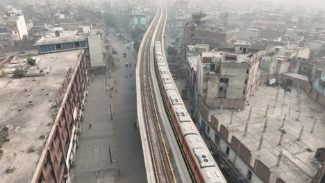 Perspectiva-Aérea-De-La-Línea-Naranja-De-Lahore,-Particularmente-Sobre-El-Puente-Que-Conecta-La-Ciudad.