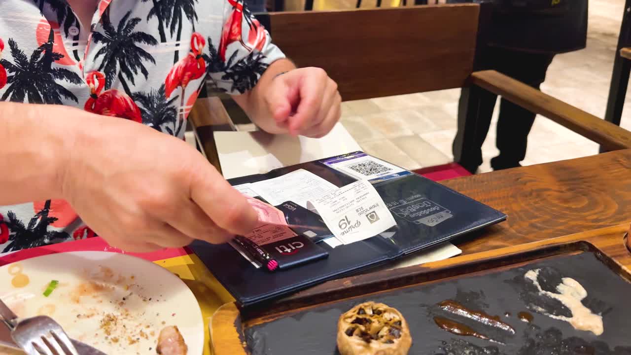 un hombre paga la cuenta en una mesa de un restaurante.