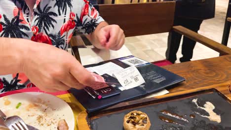 un hombre paga la cuenta en una mesa de un restaurante.