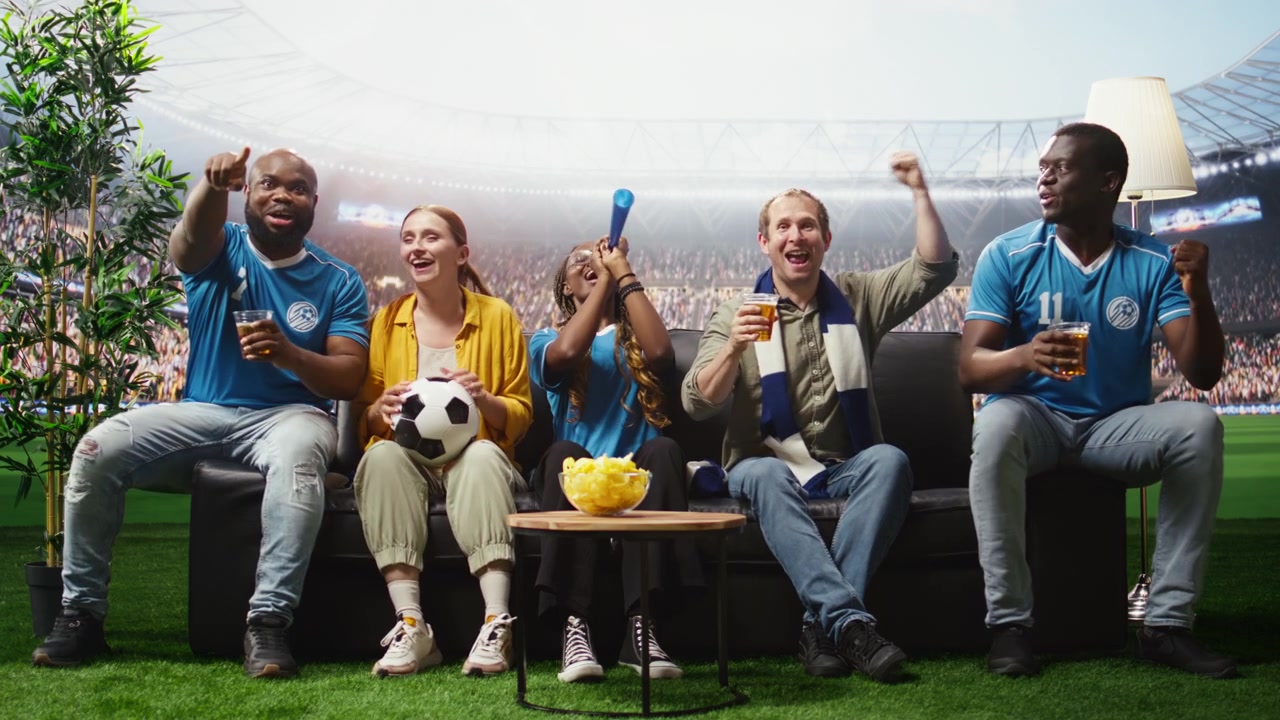 Aficionados de fútbol viendo un partido inmersivo que los transporta al campo del estadio.