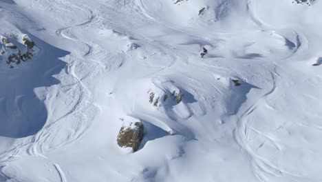 Skier-riding-down-rocky,-natural-powder-snow-slopes-and-crashing---handheld-view