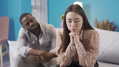 asian woman not talking to her african partner. african male trying to apologize.