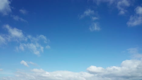 a blue sky with partly cloudy puffs of white