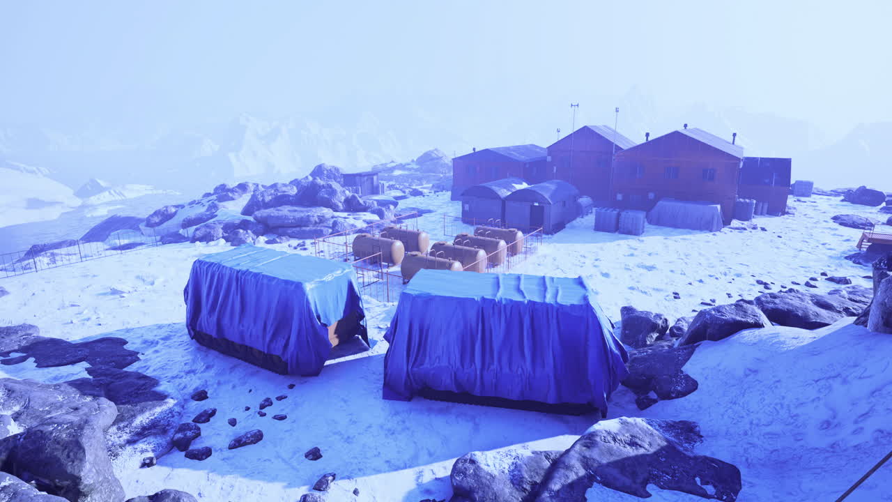 Winter landscape showcasing remote mountain camp under a blue sky