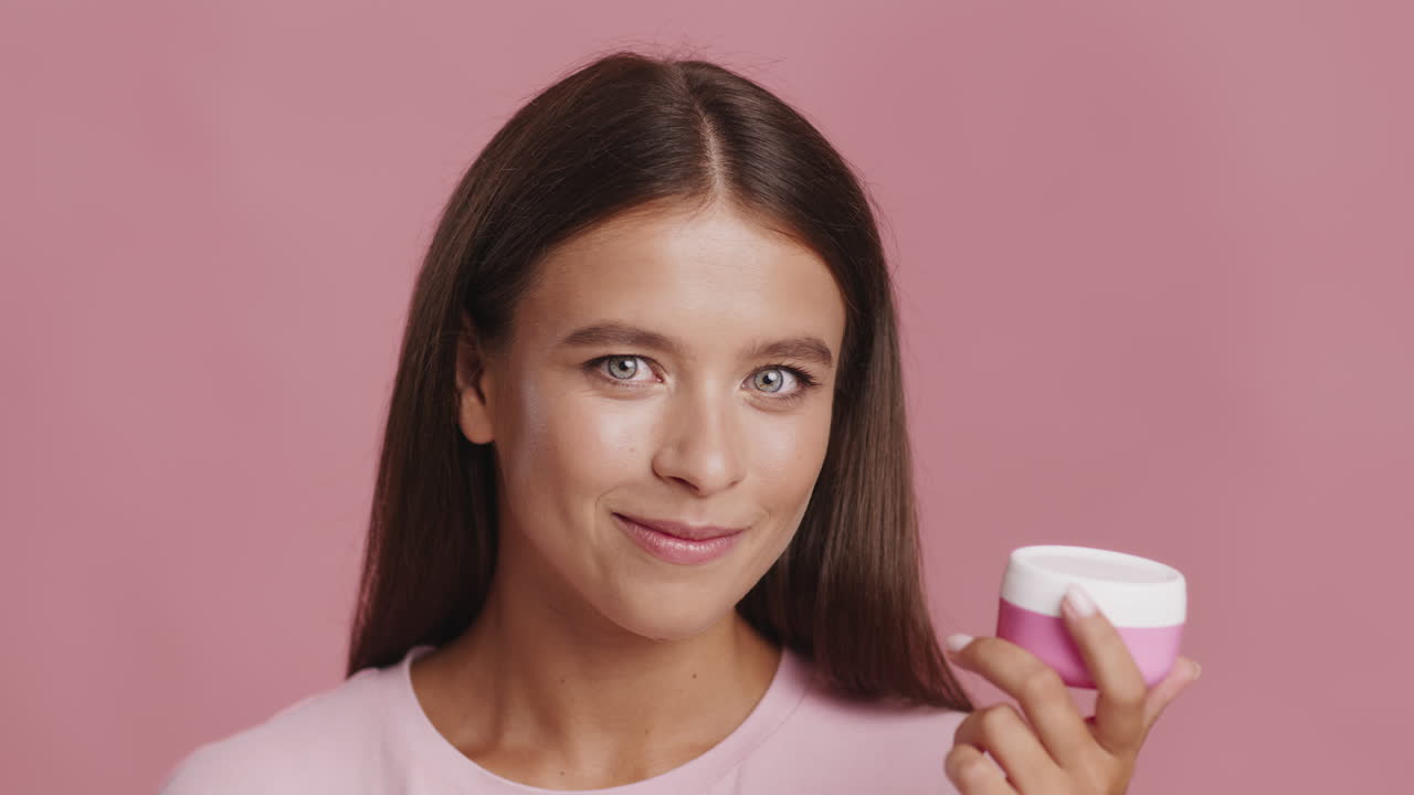 Woman Holding a Pink Skincare Product