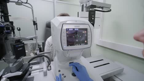 woman doctor is viewing through ophthalmoscope in eyes of patient in ophthalmologic clinic. professional inspection of vision