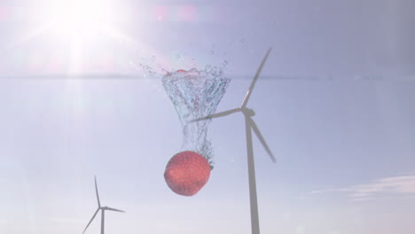 animation of strawberry falling into water over turning wind turbine