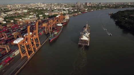 Logistic-concept-aerial-View-of-maritime-transport-commercial-dockyard-with-cargo-ships,-containers-waiting-to-be-Upload-and-Offload-Cargo-Containers