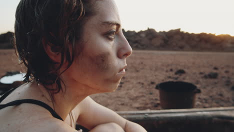 shivering woman in dirty bathtub in dystopian world