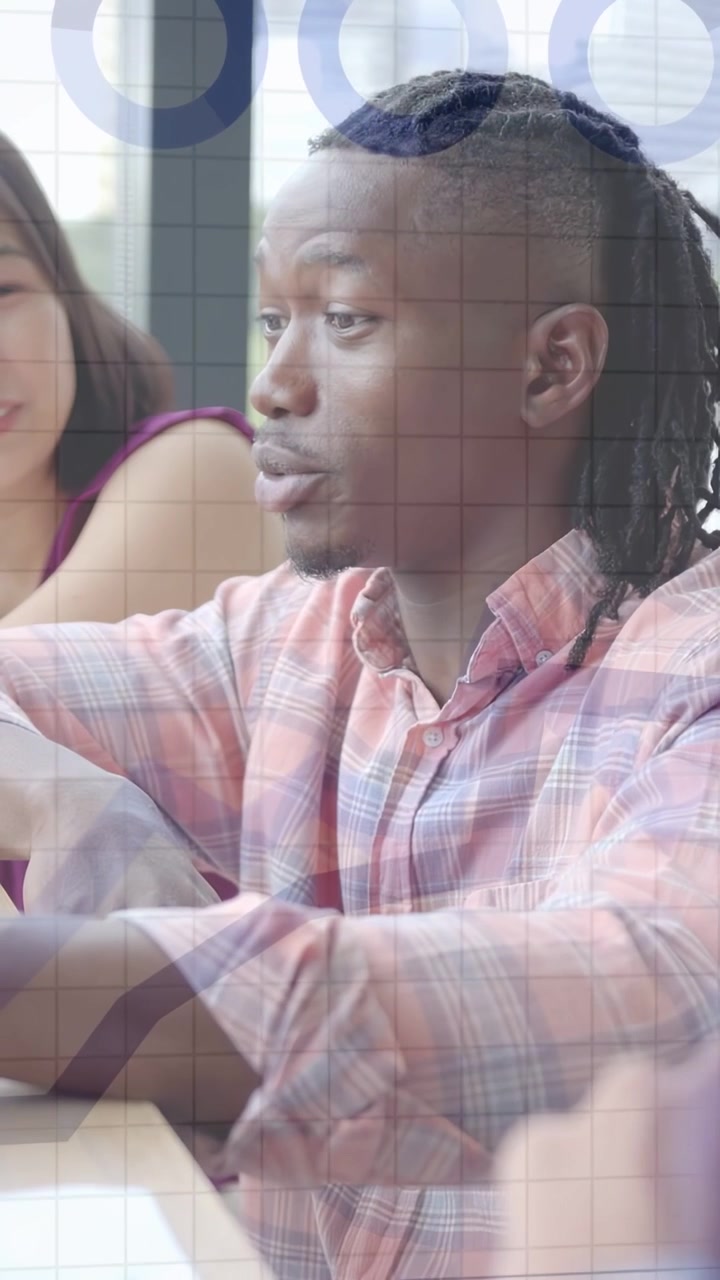 Vertical video: Man talking pointing in team meet reaching pad making graph overlay COLLECTING DATA