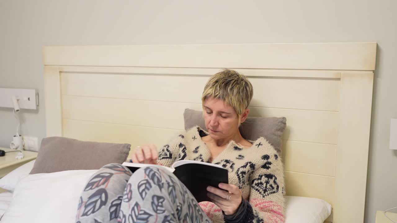 Femme lisant un livre dans le lit