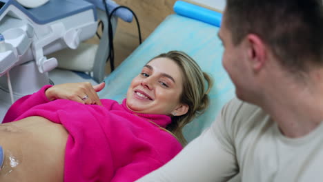 happy future parents see their baby on the ultrasound monitor. examination of pregnancy at hospital.