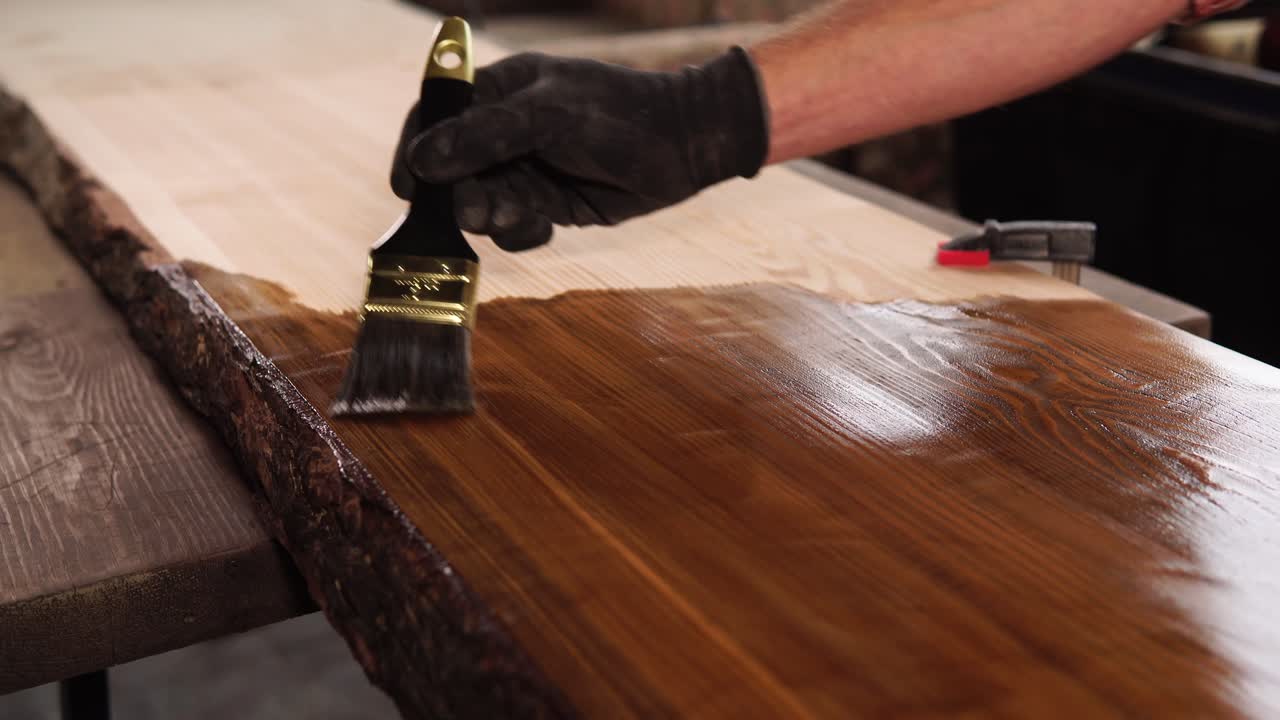 la aplicación de la mancha a una tabla de la losa de madera