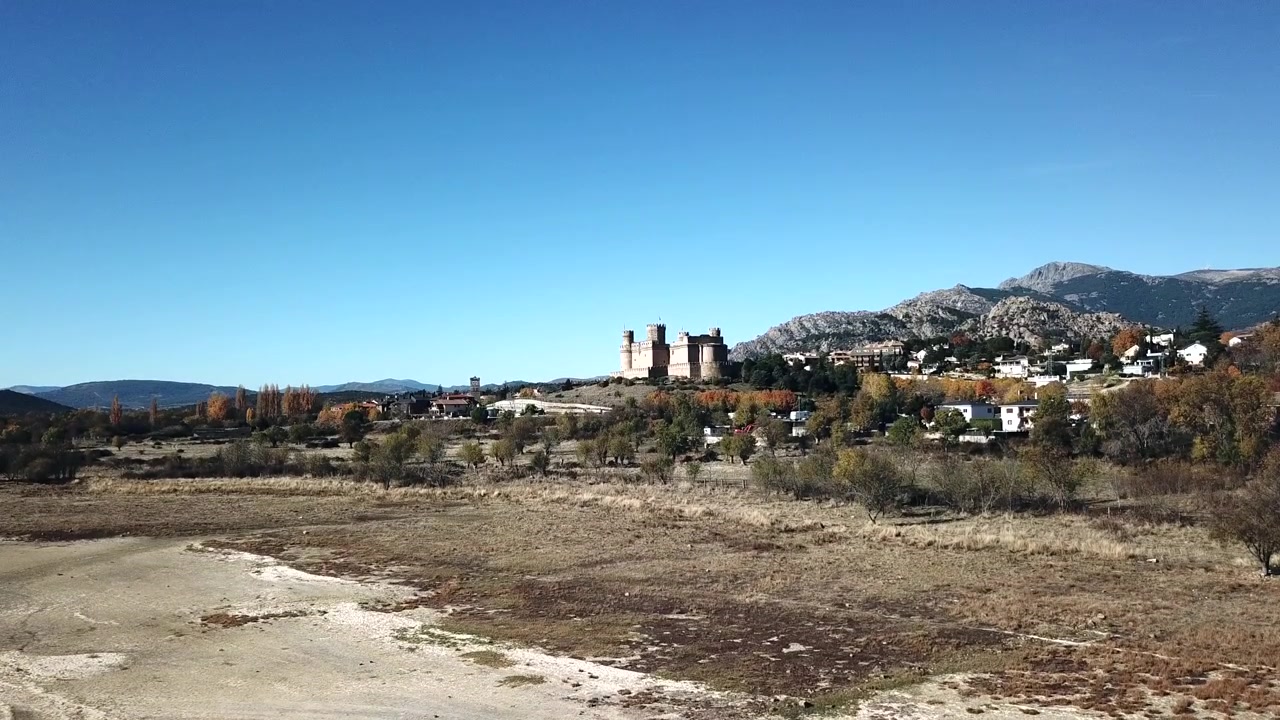 Filmato aereo del villaggio di Manzanares el Real e del castello medievale nella regione di Madrid, Spagna. Il castello storico si erge contro le montagne della Sierra de Guadarrama con il bacino di Santillana.