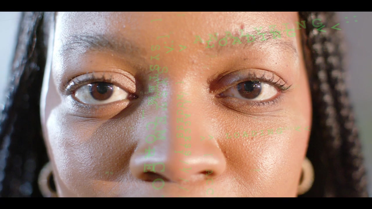 Femme immobile pendant qu'une incrustation verte initie un scan biométrique, ses yeux effectuant de légers mouvements de regard.