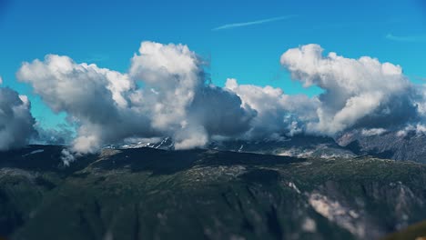 greyish-white clouds whirl and hoover above the green plateau