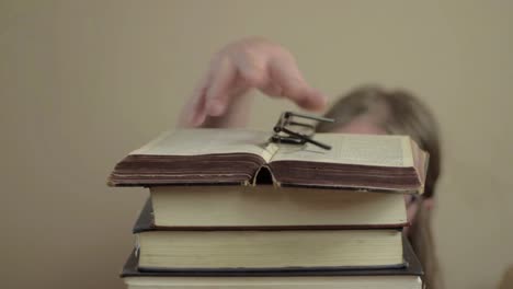 Forgetful-woman-misplaced-glasses-on-pile-of-books