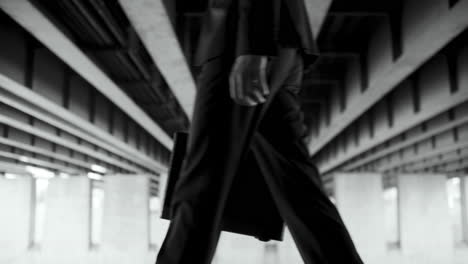 businessman walking under a bridge