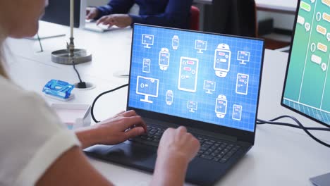 una mujer de negocios caucásica usando una computadora portátil con procesamiento de datos en la pantalla de la oficina.