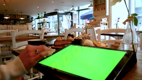 mujer usando una tableta grande en un café